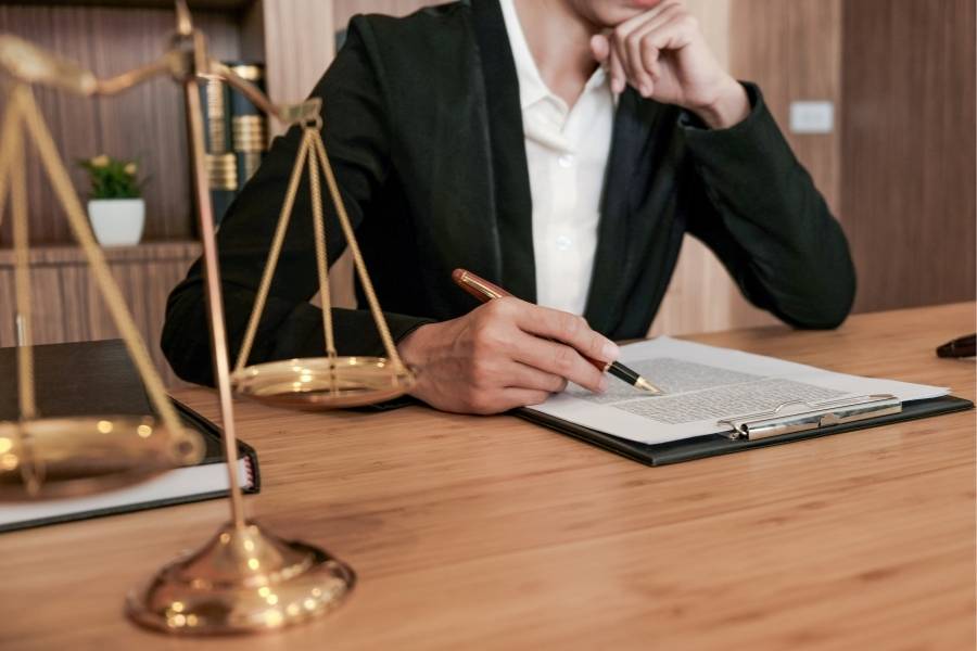 Lawyer reviewing legal documents with justice scales on desk – Timeshare Be Gone services in Alaska