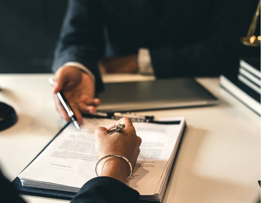 Client reviewing and signing legal documents with a timeshare exit consultant—illustrating TimeshareBeGone’s professional timeshare cancellation services in Massachusetts.