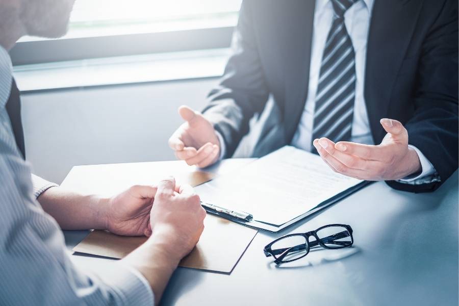 Two men in a business meeting discussing timeshare contract cancellation—TimeshareBeGone helps Vermont residents understand exit strategies and legal options.
