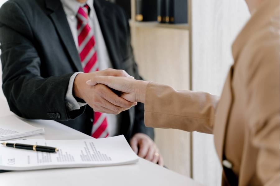 Business professional shaking hands with client after reviewing legal documents for timeshare cancellation in Wisconsin.