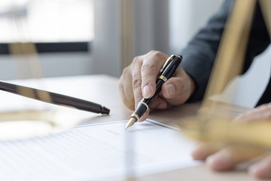 Close-up of a lawyer signing legal documents for timeshare cancellation in Wyoming.