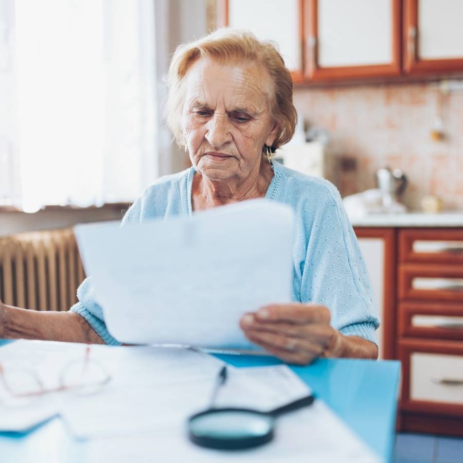 Elderly woman reviewing documents for timeshare cancellation in Alaska