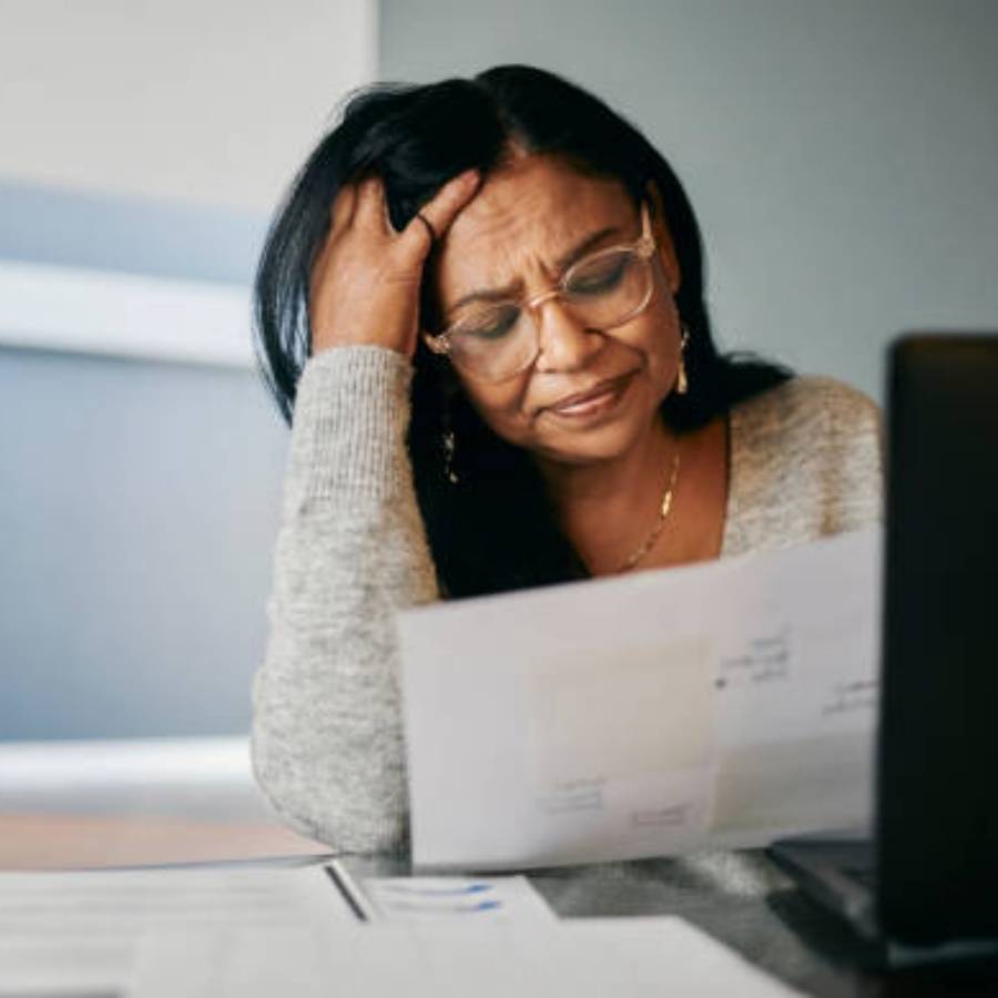 Stressed woman reviewing timeshare cancellation documents in California at home office desk