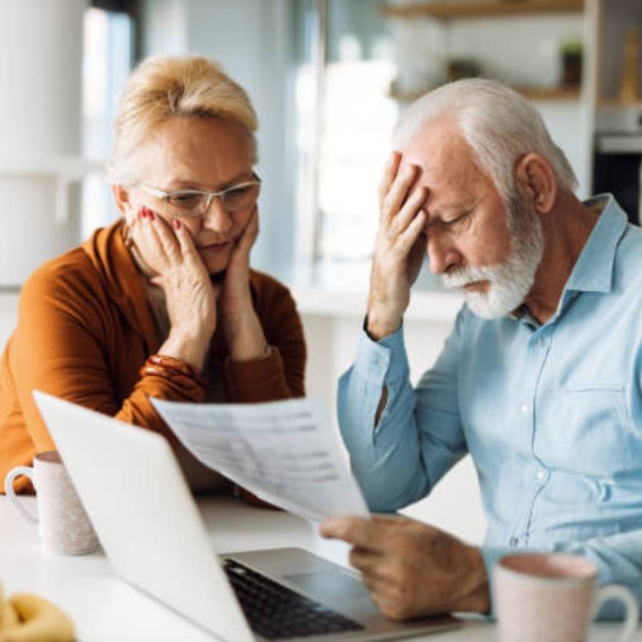 Worried senior couple looking over timeshare cancellation documents in Colorado.
