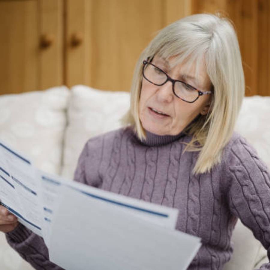 Senior woman reviewing timeshare cancellation documents at home in Connecticut