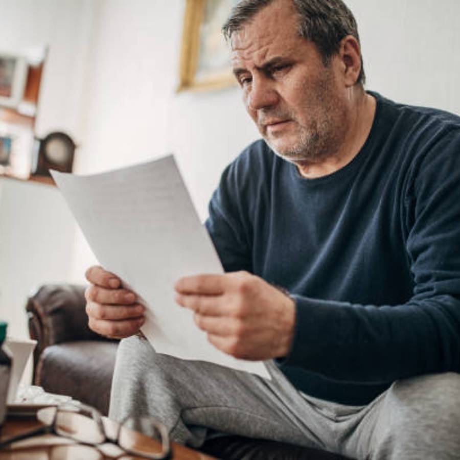 Middle-aged man reviewing timeshare cancellation paperwork at home