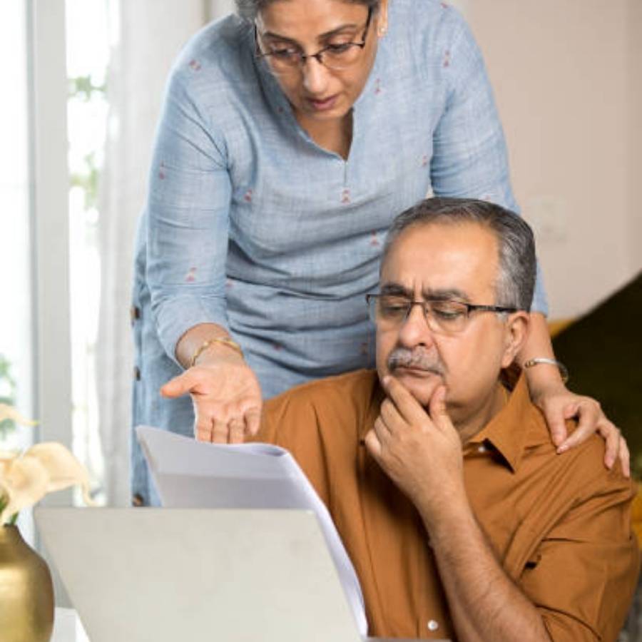 Concerned couple reviewing timeshare cancellation documents on laptop at home