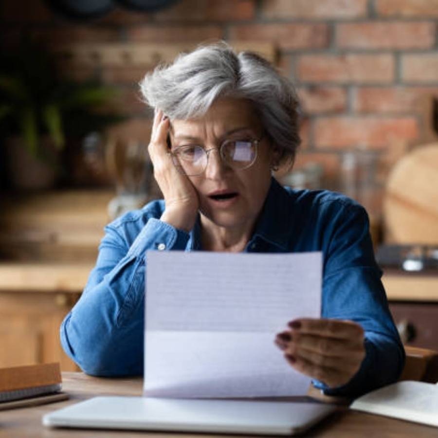 Shocked senior woman reading timeshare cancellation notice at home