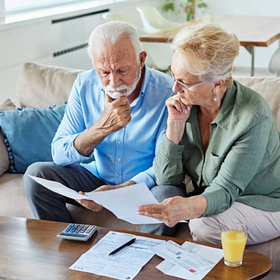 Senior couple reviewing timeshare cancellation paperwork and bills at home