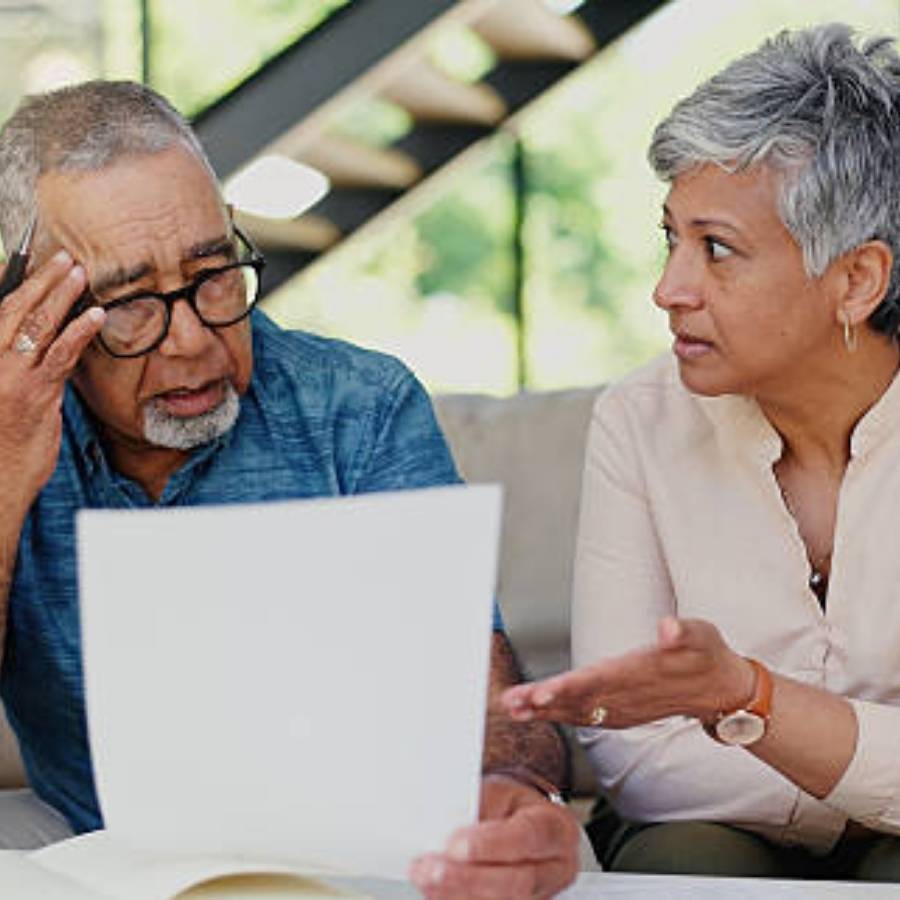 Frustrated senior couple discussing timeshare cancellation paperwork at home