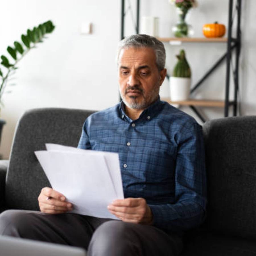 Middle-aged man reading timeshare cancellation paperwork at home