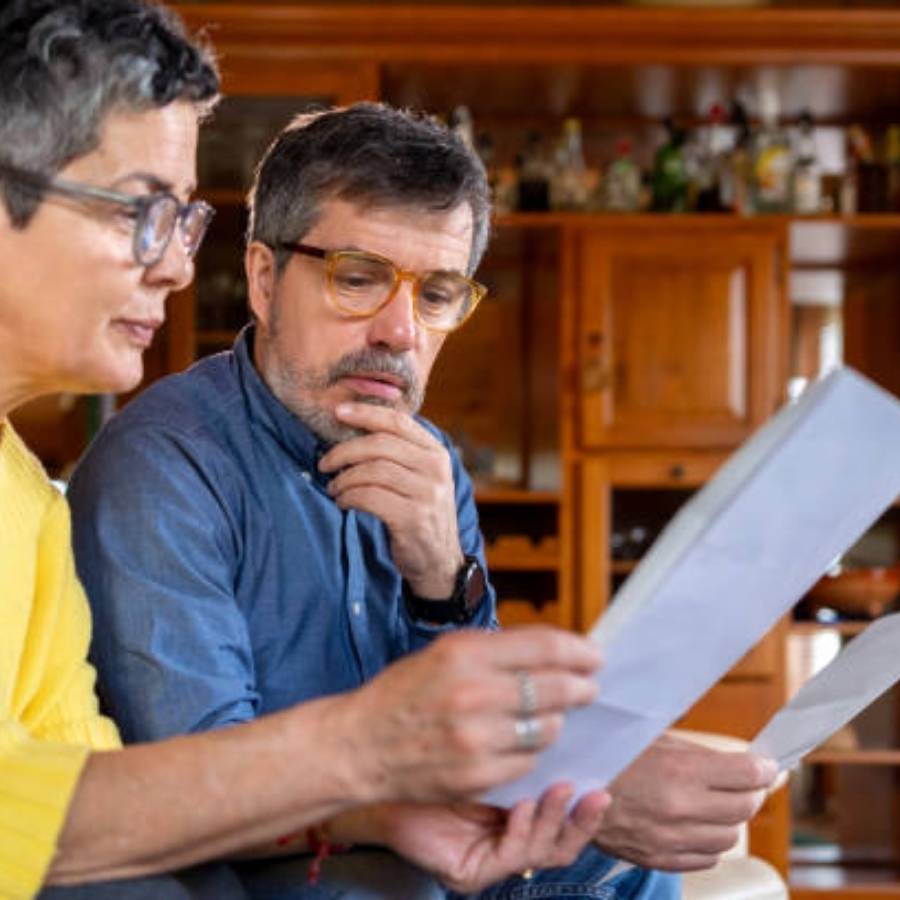 Middle-aged couple reviewing timeshare cancellation documents together at home