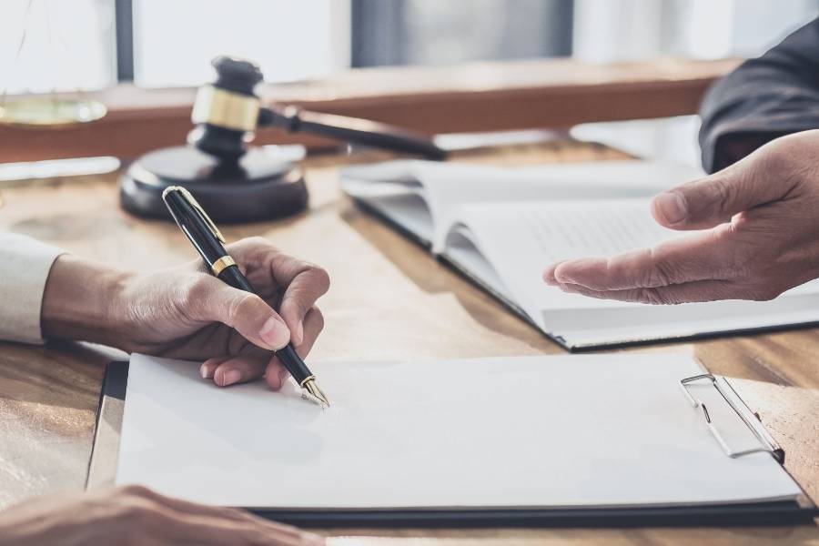 Lawyer guiding client through signing timeshare cancellation documents in Raleigh, North Carolina