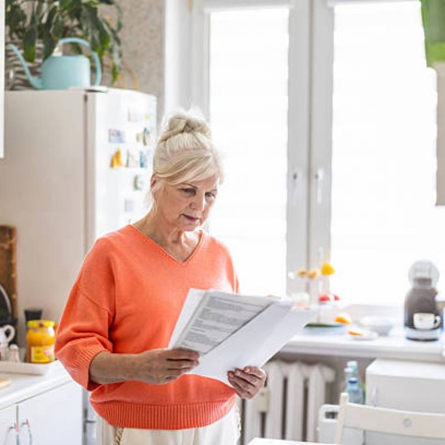 Older woman reading timeshare cancellation documents at home in Atlanta, Georgia