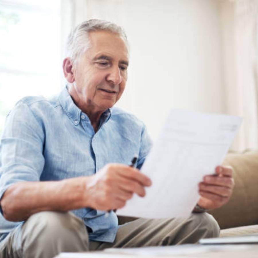 Older man reviewing timeshare cancellation paperwork at home in Macon, Georgia