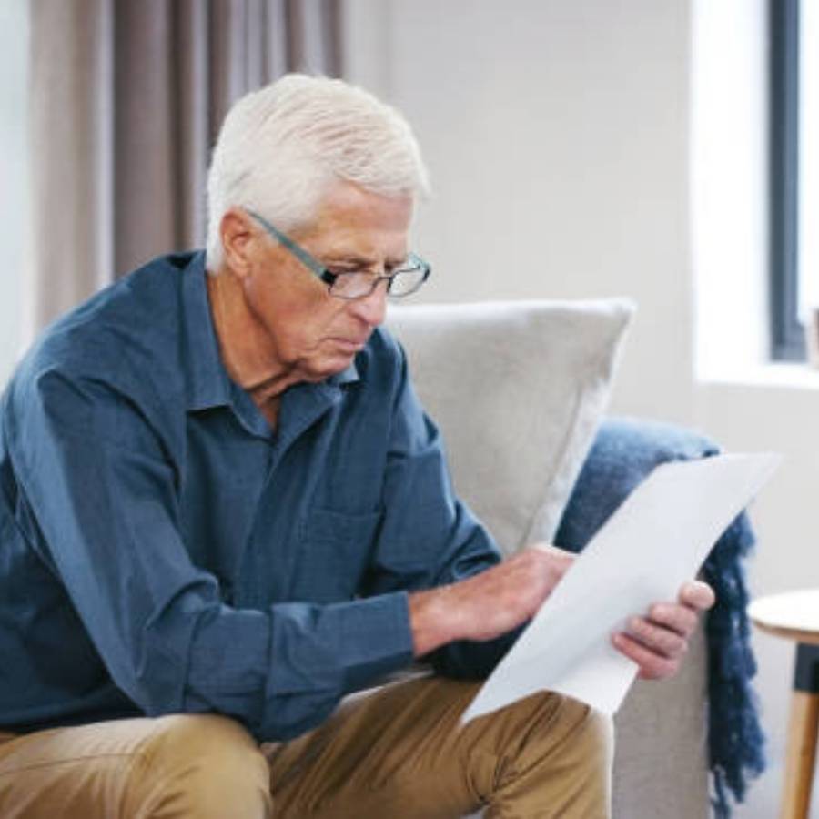 Senior man looking over timeshare cancellation documents at home in Savannah, Georgia
