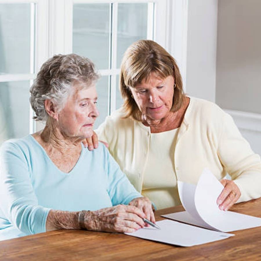 Two women reviewing timeshare cancellation paperwork together in Tallahassee, Florida.
