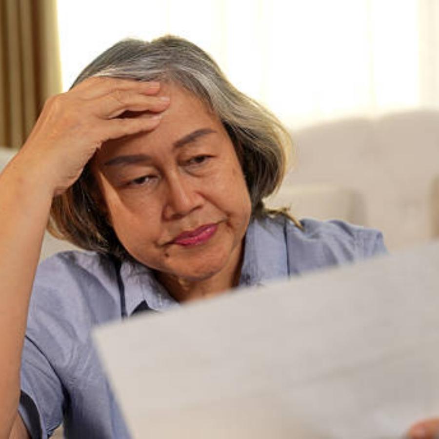 stressed senior woman reviewing a timeshare contract